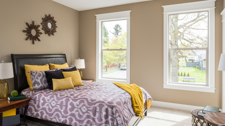 Bedroom with two windows lacking window treatments