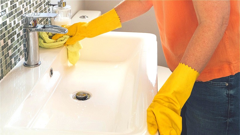 Person cleans bathroom sink