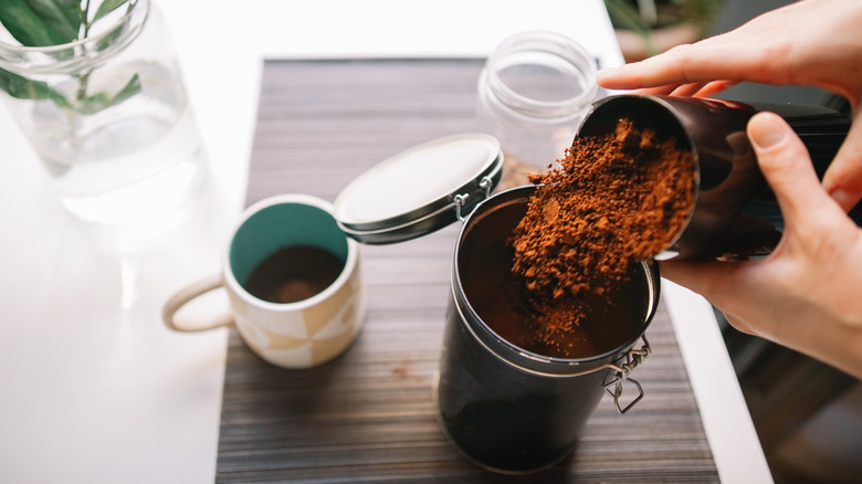 Putting coffee grounds in jar