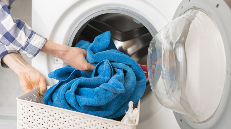 Putting blue towel in washer