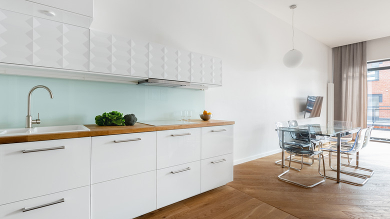 Blue tinted glass sheet backsplash in small kitchen