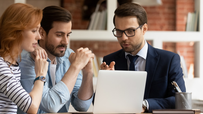 couple and man looking at laptop