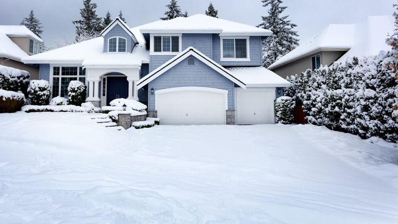 Snow covering a driveway outside a house
