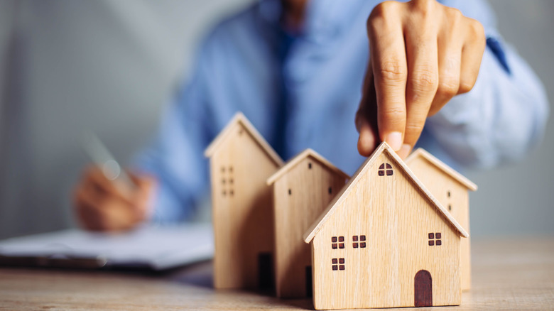 hand and wooden miniature houses 