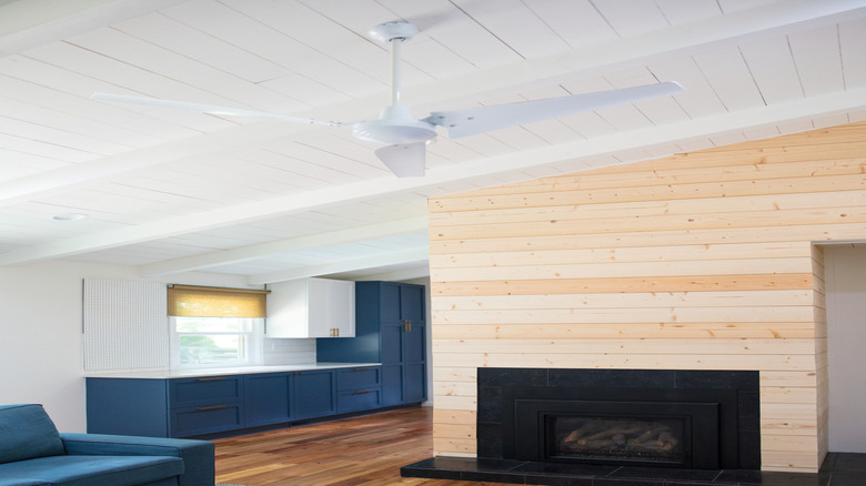 White wood paneling on a ceiling. A ceiling fan hangs down.
