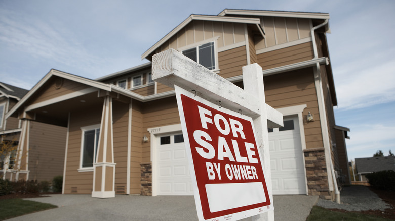 House with For Sale By Owner sign in front