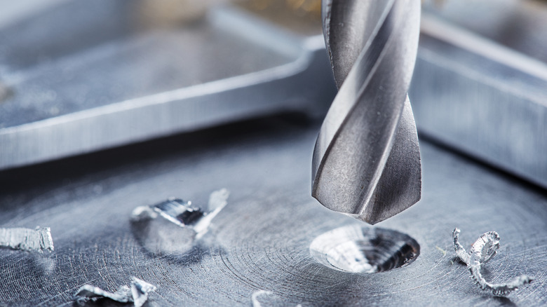 A close-up shot of a drill bit boring into a metal surface