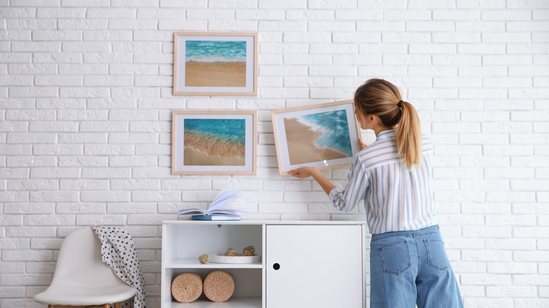 Woman hanging beach pictures