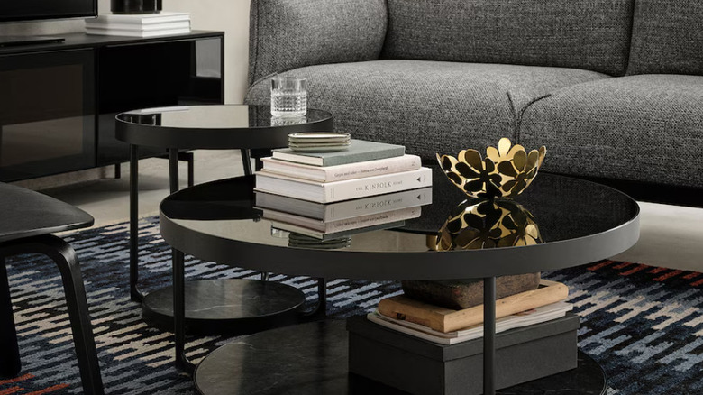 A round black coffee table with a stack of books on top.