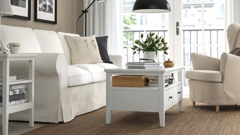A white coffee table next to a white couch