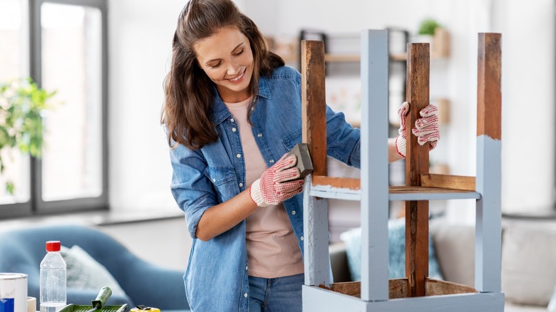 Woman painting a stool blue