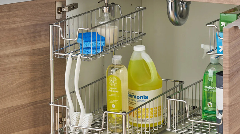 Steel slide-in organizers loaded with cleaning supplies under the sink