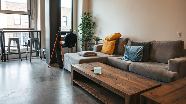 grey couch with dark wood coffee tables in city apartment