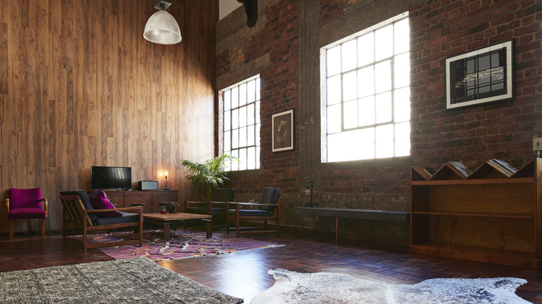 room with dark wood paneling on walls and dark wood floors