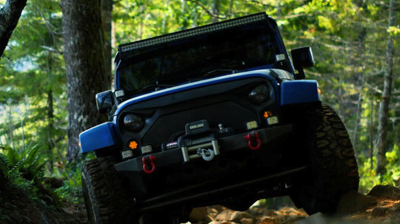 Off-road vehicle in the woods with a badland winch mouted to the front