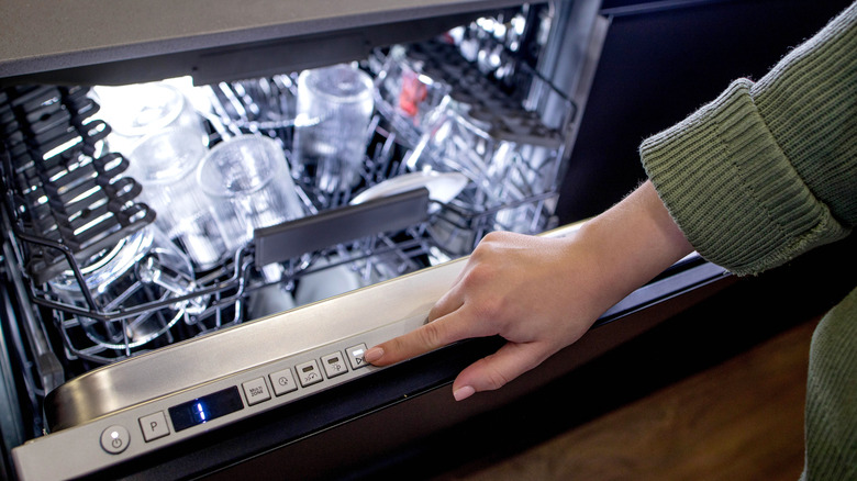 Someone selecting their dishwasher setting