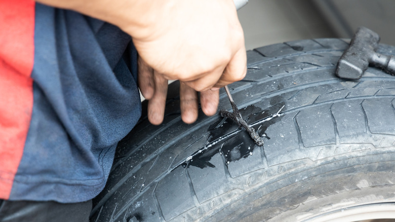 person using a plug kit to repair hole in tire
