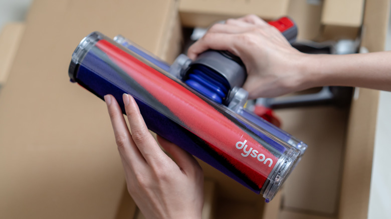 person unboxing Dyson vacuum