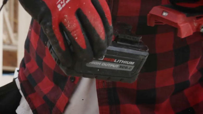 Man holding Milwaukee M18 battery
