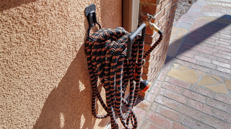 Flexible garden hose on holder