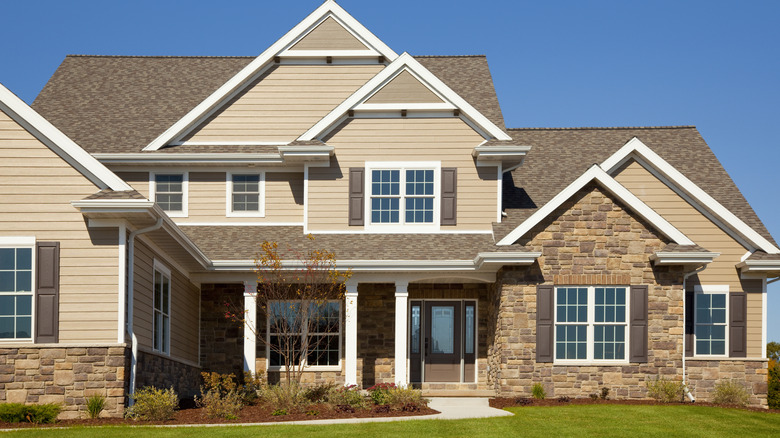 A warm beige house with a light brown roof.