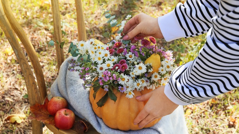 person making autumn flower arrangement