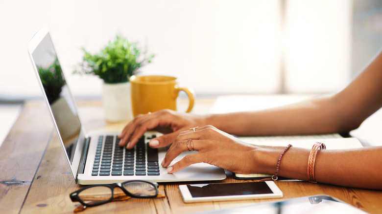 Female hands typing in prompts on a computer