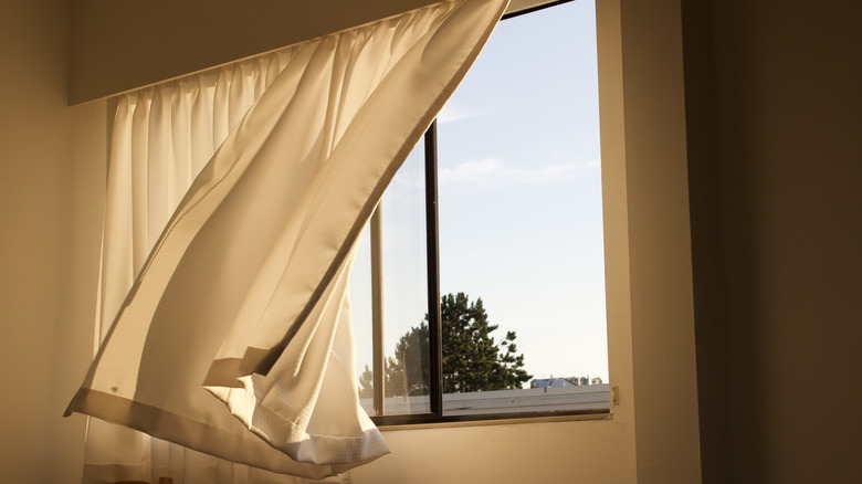 Curtains blowing in wind in front of open garage window