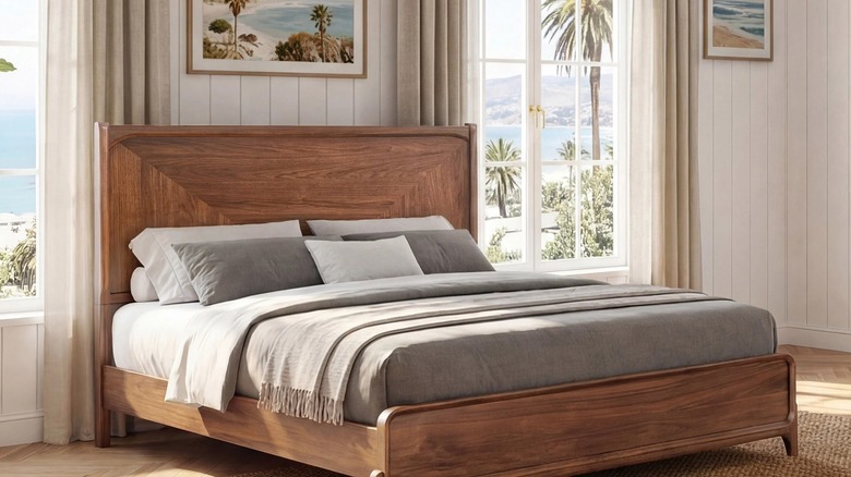 A Rockford Panel Bed Frame in a modern bedroom with a view of a tropical beach out the window.