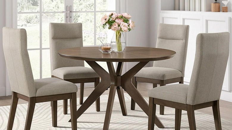 The Sophie 48-Inch Round Dining Table and 4 Chairs set in a dedicated dining room with French doors overlooking a garden.