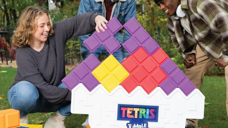 Teenagers playing a real-life giant Tetris game outdoors in the backyard.