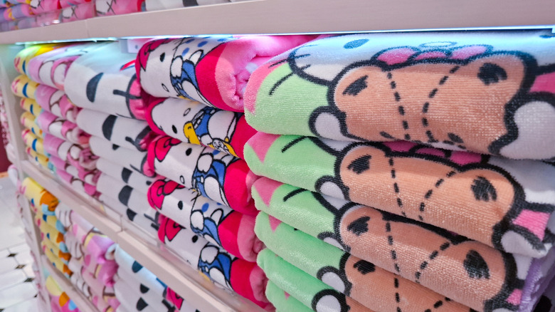 Folded Hello Kitty throw blankets on a shelf with various patterns