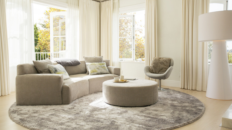 A curved sofa and round coffee table 