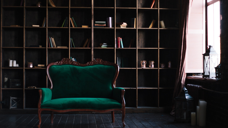 A dimly lit library with green chair