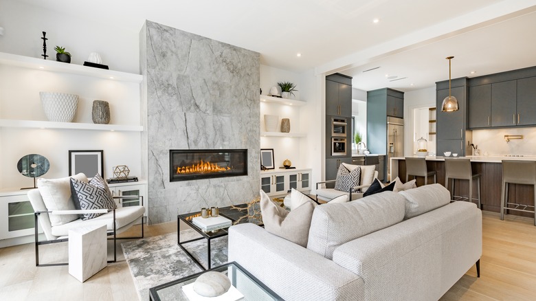 A stone wall enclosing a modern fireplace in a living room 
