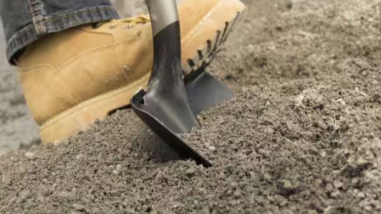 A person uses a boot to dig with the PowerEdge square point shovel