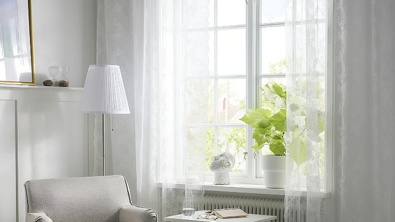 ALVINE SPETS curtains hanging on a window next to an armchair, table, and white lamp