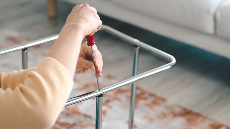 A person assembling chrome furniture