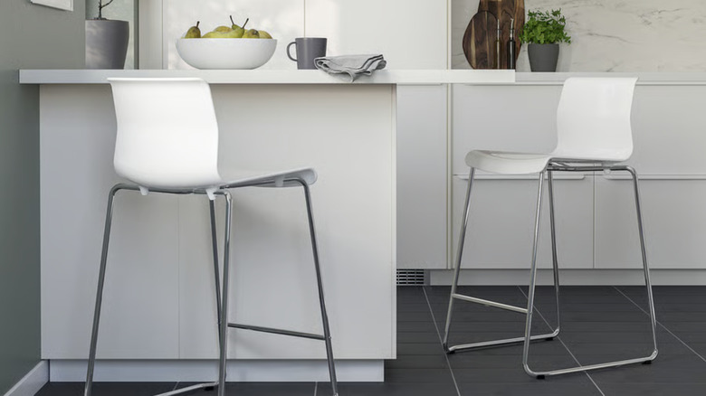 Two white and chrome IKEA barstools at a counter