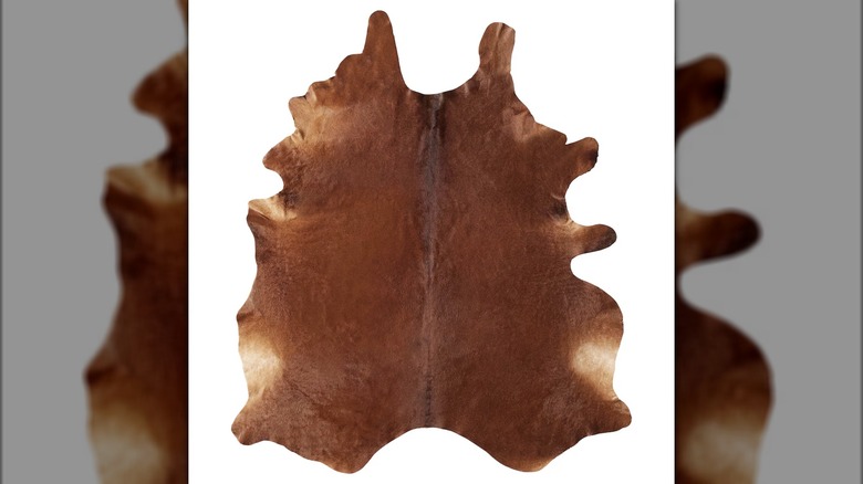 A brown KOLDBY cowhide rug is shown in a detail shot