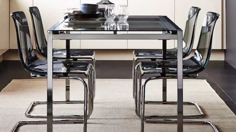 A modern chrome table and chairs sit on a beige MORUM rug from IKEA