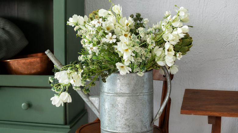 Watering can growing wildflowers