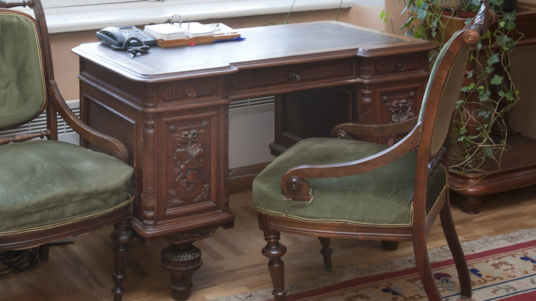 A dark wood vintage writing desk and chair.