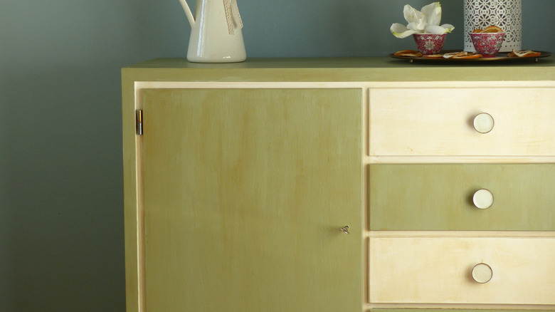 A green vintage dresser with accessories.