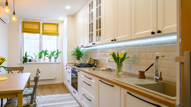 Cozy, modern kitchen interior with yellow shades and matching place mat and flowers.