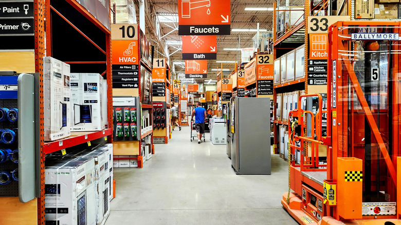 Home Depot aisles with refrigerators and signs.