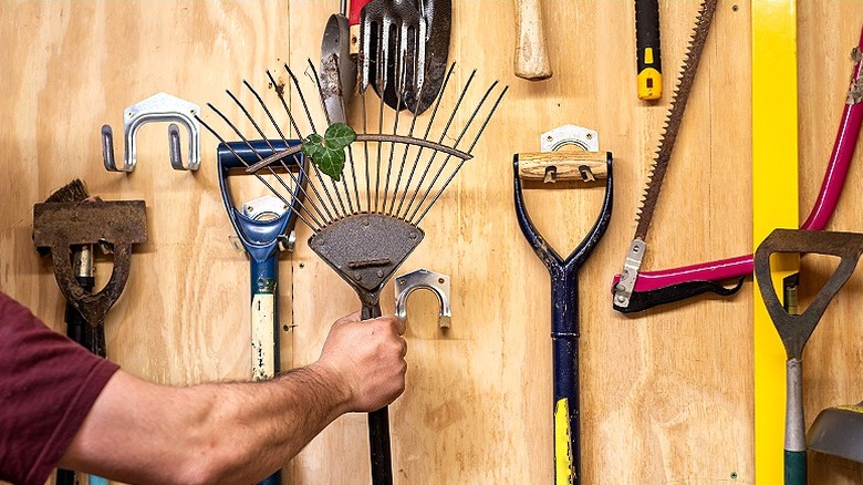 Person grabbing a leaf rake