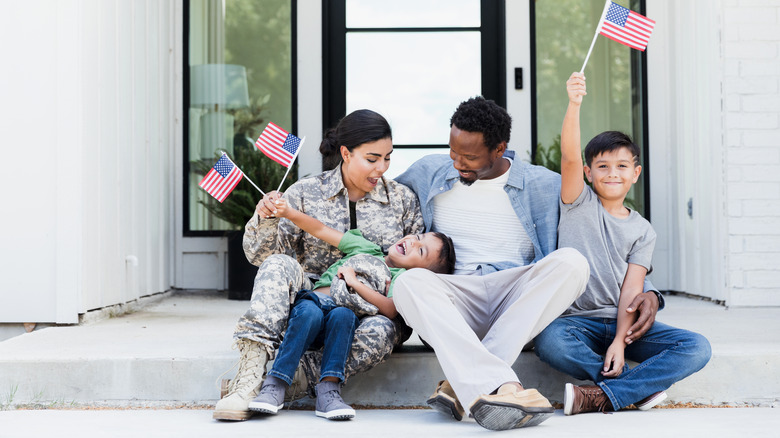 Family waving flags on porch