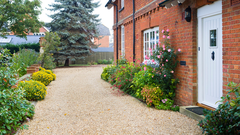 Red brick house with gravel driveway