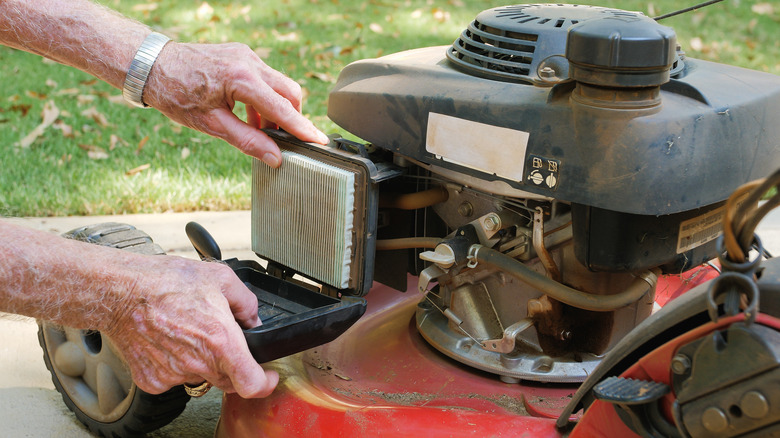 person checking lawnmower air filter